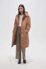 Campera larga tipo parka acolchada color negro, con capucha desmontable, cierre frontal con botones a presión, bolsillos laterales y cordón ajustable en la cintura.