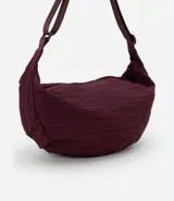 Bolso hobo color borgoña con textura plisada, correa transversal ajustable y cierre de cremallera.