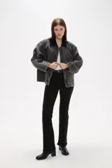 Campera de jean con lavado gris desgastado, cuello camisero en pana negra, cierre frontal con botones y bolsillos laterales amplios.
