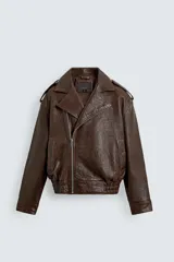 Cazadora biker de corte oversize confeccionada en piel color marrón. Presenta cuello con solapas de pico, cierre frontal asimétrico con cremallera, bolsillos laterales de vivo y bajo con elástico. Las mangas largas cuentan con puños ajustables con cremallera.