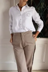 Pantalón de corte sastrero con pierna recta, confeccionado en gabardina y tencel. Presenta un diseño en color beige con detalle de rayas laterales en contraste.