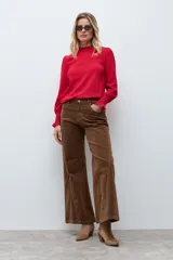 Blusa de color rojo con cuello alto y detalle de volados, mangas largas con puños elásticos en punto smock y textura sutil en la tela.