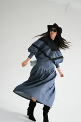 Blusa con cuello mao y mangas globo, confeccionada en algodón. La parte superior es de rayas azules y blancas, y la parte inferior es blanca con detalles de encaje.