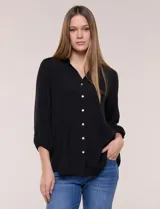 Blusa celeste de silueta suelta y textura liviana, con escote en V, cuello mao y cierre frontal de botones. Cuenta con alforzas verticales en el pecho y mangas tres cuartos con puños elastizados y detalle de galón calado.