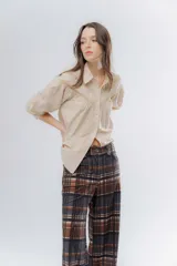 Pantalón de corte recto con estampado a cuadros en tonos marrones y rosados. Presenta una pretina elástica para mayor comodidad y está confeccionado en una tela acanalada con caída suave.