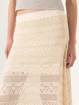 Pollera larga color crudo, confeccionada en tejido calado con lurex, cintura elastizada y forro interno.