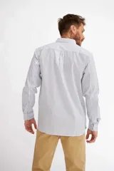 Camisa de manga larga con diseño de rayas verticales blancas y azules, cuello camisero y cierre frontal con botones.