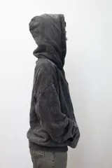 Canguro negro con capucha y bolsillo tipo canguro. Diseño con efecto gastado y logo bordado en el pecho.