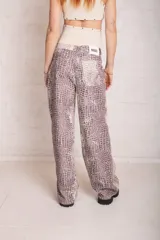 Pantalón de jean de corte ultra baggy y holgado, con pierna ancha, tiro bajo y estampado de efecto cocodrilo.