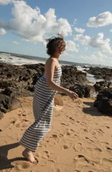 Vestido largo de lino a rayas verticales azules y blancas, con breteles finos y corte recto.