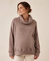 Polerón de punto inglés color marrón topo, con cuello alto tipo polera, mangas largas y cierres laterales decorativos.