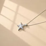Collar de cadena fina de plata 925 con dije en forma de estrella, con centro de resina color azul oscuro y borde plateado.