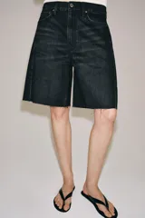 Bermuda de denim color bordó, de tiro medio y corte relaxed, con diseño de cinco bolsillos, trabillas para cinto y bajo desflecado.