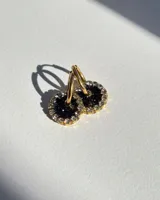 Aros de acero quirúrgico con dije circular de resina rosa y borde de strass dorados.