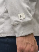 Remera de manga larga con cuello redondo, confeccionada en algodón, de corte clásico y diseño minimalista con detalle de etiqueta pequeña en el ruedo.