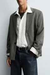 Blazer de corte boxy fit con estampado de espiga. Presenta cuello con solapas de muesca, cierre frontal de un botón, mangas largas con puños abotonados y bolsillos con solapa en la cadera.