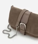 Cartera bandolera pequeña de estructura rígida en gamuza sintética color marrón. Presenta una tapa frontal con detalle de tira central y hebilla decorativa, y una correa larga de cadena metálica.