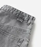 Bermuda masculina de jeans denim color gris lavado, modelo baggy con corte recto y holgado. Presenta detalles de costura en el bajo y está confeccionada con algodón certificado BCI.