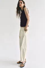 Pantalón de tiro bajo estilo chino, color blanco, con bolsillos delanteros, bolsillos de plastrón en la espalda y bajo acabado con vuelta. Cierre frontal con cremallera y botón.