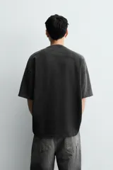 Remera de algodón con corte relajado, cuello redondo y mangas cortas. Presenta un efecto de lavado desgastado y un estampado frontal con motivos de suerte y casino.