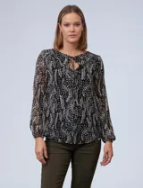 Blusa de gasa estampada en blanco y negro, marca Tahari. Tiene cuello redondo con escote en V y lazo, mangas largas con puño elastizado y forro a tono.