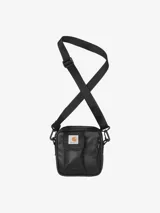 Bolso tipo morral Carhartt en color negro, con correa ajustable y desmontable. Presenta un bolsillo frontal con solapa y cierre de velcro, junto con un compartimento principal con cierre de cremallera. Incluye el logo de la marca en la parte frontal.