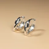 Aros tipo argolla de plata 925 con diseño entrelazado y acabado brillante.