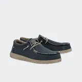 Zapatos Hey Dude modelo Wally Braided, confeccionados en tejido textil color marrón con cordones elásticos beige, costuras visibles en el empeine y suela ligera de goma.