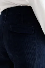 Pantalón de pana de corte wide leg, color verde oliva, con cierre frontal y bolsillos laterales.