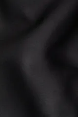 Pantalón negro de tejido liso, corte amplio y tiro alto con cintura elástica.