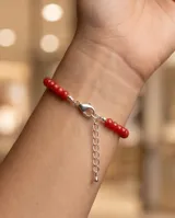 Pulsera de plata 925 con cuentas facetadas de cristal rojo y pequeños tubos plateados intercalados. Incluye cadena de alargue y cierre de mosquetón.