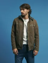 Campera de tejido técnico elástico en color verde oliva, con capucha integrada, cierre frontal y bolsillos laterales con cierre. Presenta un diseño funcional con forro interior de micro polar.