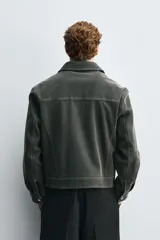 Cazadora de corte boxy fit en tejido efecto ante con acabado vintage. Presenta cuello solapa, cierre frontal con cremallera, bolsillos de plastrón en la cadera y costuras a contraste en toda la prenda.