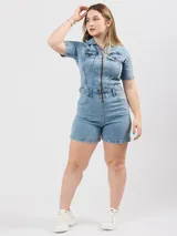 Mono corto de jean color celeste, con cierre frontal, cuello camisero y bolsillos delanteros y traseros.