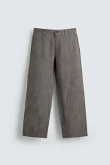 Pantalón de traje de corte slim fit, color marrón con textura sutil. Cuenta con cierre frontal de cremallera y botón, bolsillos laterales y bolsillos traseros de doble vivo con botón.
