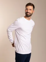 Remera blanca de manga larga con cuello redondo y logo bordado de un pájaro en el pecho.