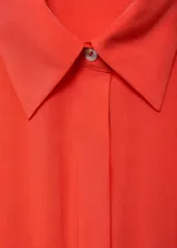 Vestido midi de modal con diseño evasé, cuello camisero y cierre frontal de botones. Presenta mangas cortas, detalle de tablas en la falda y cinturón ajustable con hebilla a tono.