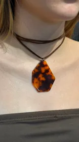 Gargantilla tipo choker con cordón de gamuza marrón y dije geométrico de resina con estampado tipo carey.