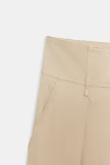Pantalón de tiro bajo con pinzas delanteras, bolsillos frontales y bolsillos de plastrón con solapa en la parte trasera. Presenta una pernera ancha y bajo con botones a presión para ajuste.