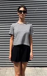 Camiseta de manga corta gris con rayas horizontales negras y cuello redondo.