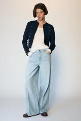 Jeans de tiro medio con diseño wide leg y pernera ancha. Presenta cinco bolsillos, cierre frontal con cremallera y botón, y detalle de raya planchada en el delantero y la espalda.