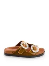 Sandalia tipo slide con doble tira de terciopelo en color mostaza, hebillas circulares con apliques de strass y plantilla de cuero.
