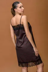 Vestido lencero de satén con estampado de lunares, breteles finos regulables y detalles de puntilla negra en el escote y el ruedo.