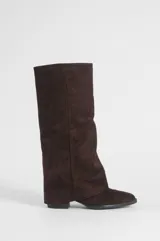 Bota de caña alta estilo slouchy en color marrón, confeccionada en material sintético con acabado efecto gamuza, puntera redondeada y taco bajo.