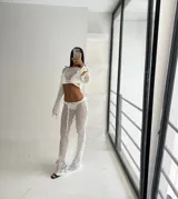 Conjunto de dos piezas de red color blanco, compuesto por un top de manga larga y una falda larga de tiro bajo con ajuste de cordón en la cintura.