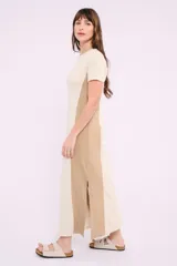 Vestido midi de corte recto y diseño bicolor, con frente en color crema y laterales en color beige. Presenta cuello redondo, mangas cortas y aberturas laterales en el ruedo.