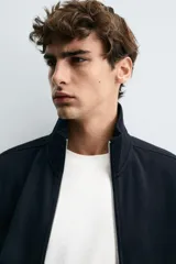 Chaqueta regular fit de tejido técnico interlock de algodón elástico, color azul marino. Presenta cuello subido, manga larga, bolsillos de vivo en la cadera, acabados en rib y cierre frontal con cremallera.