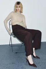 Zapato destalonado de tacón fino alto, con diseño en punta y acabado texturizado efecto cocodrilo. Cuenta con tira trasera ajustable mediante hebilla metálica.