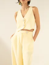 Pantalón negro de crepe con cintura cruzada, broche con brillo glitter, tiro alto, pinzado y pata ancha.