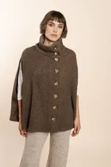Capa color beige con textura de espiga, cuello alto con botones y aberturas laterales para los brazos. Confeccionada en lana fina sin teñir.
